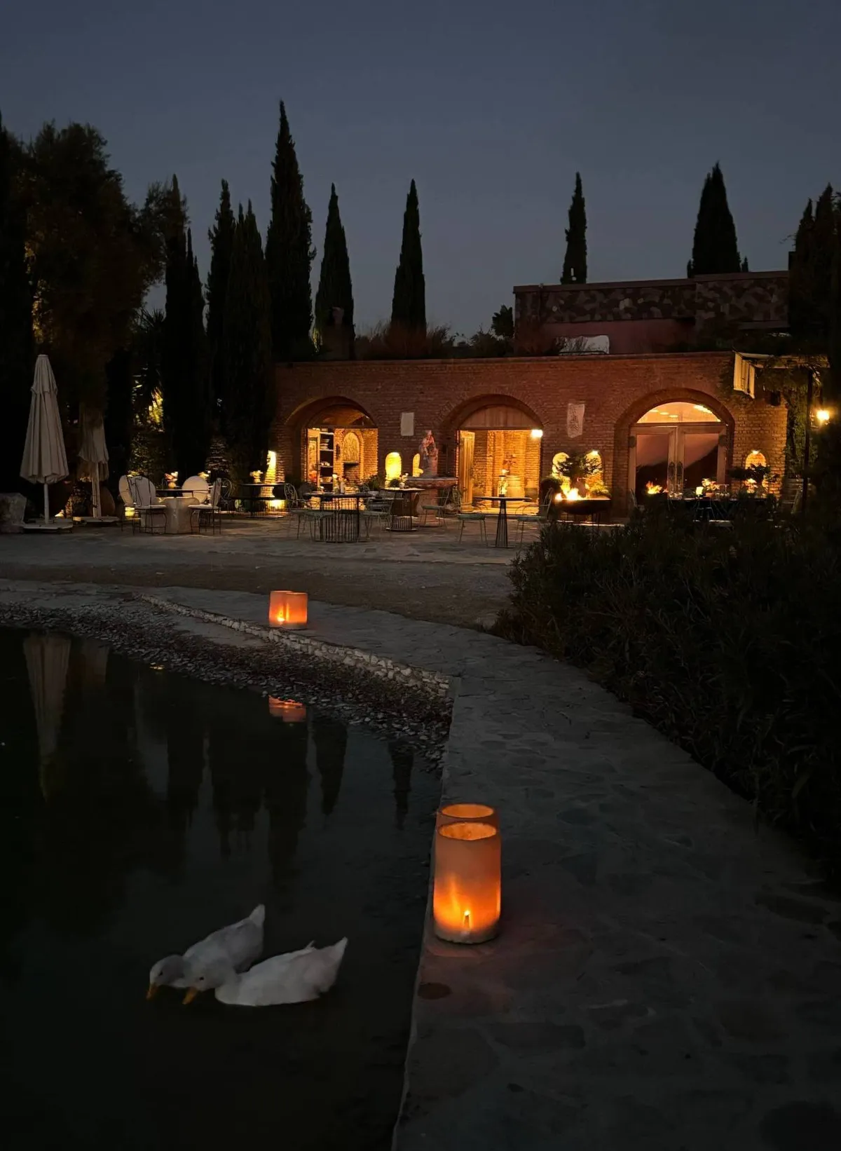 Karnas winery lit up in the evening, with candles by the pond