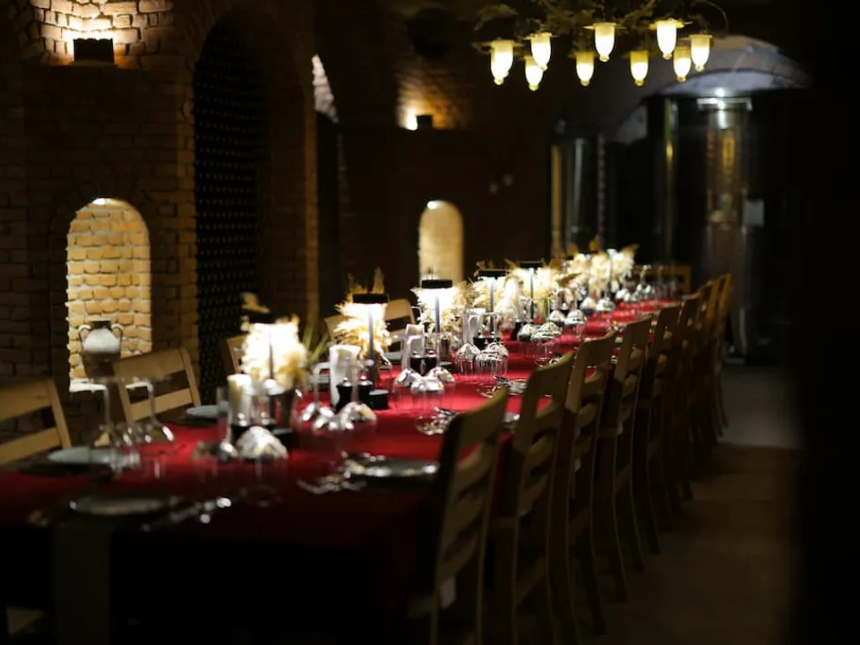 Long candle-lit dinner table set in the Karnas wine cellar